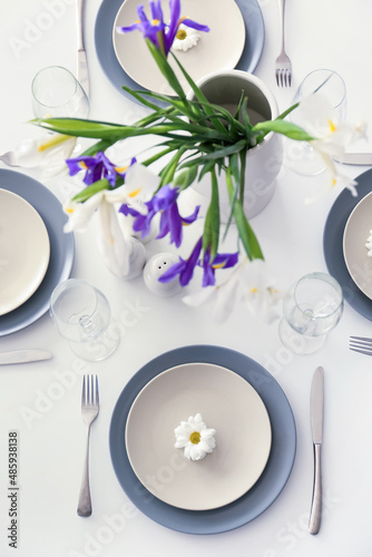 Dining table with stylish setting and iris flowers served for International Women's Day celebration, closeup