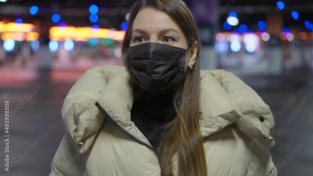 Young woman in a protective black mask on her face. Underground parking. Covid. Young woman in a protective black mask on her face. Underground parking. Covid.