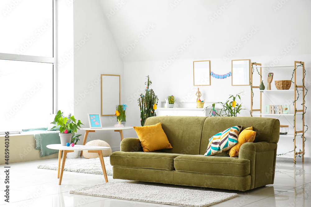 Obraz premium Interior of light living room with green sofa and Easter eggs
