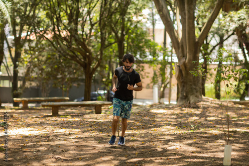 Young guy running and jogging at a park outdoors. Athlete male person during workout. High quality photo
