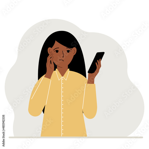 A woman looks at a mobile phone. A woman looks sadly at the phone he holds in his hand. Vector
