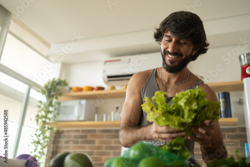 Happy and healthy young man meal prepping whole vegetarian meal in the kitchen. High quality photo © Buonaventura