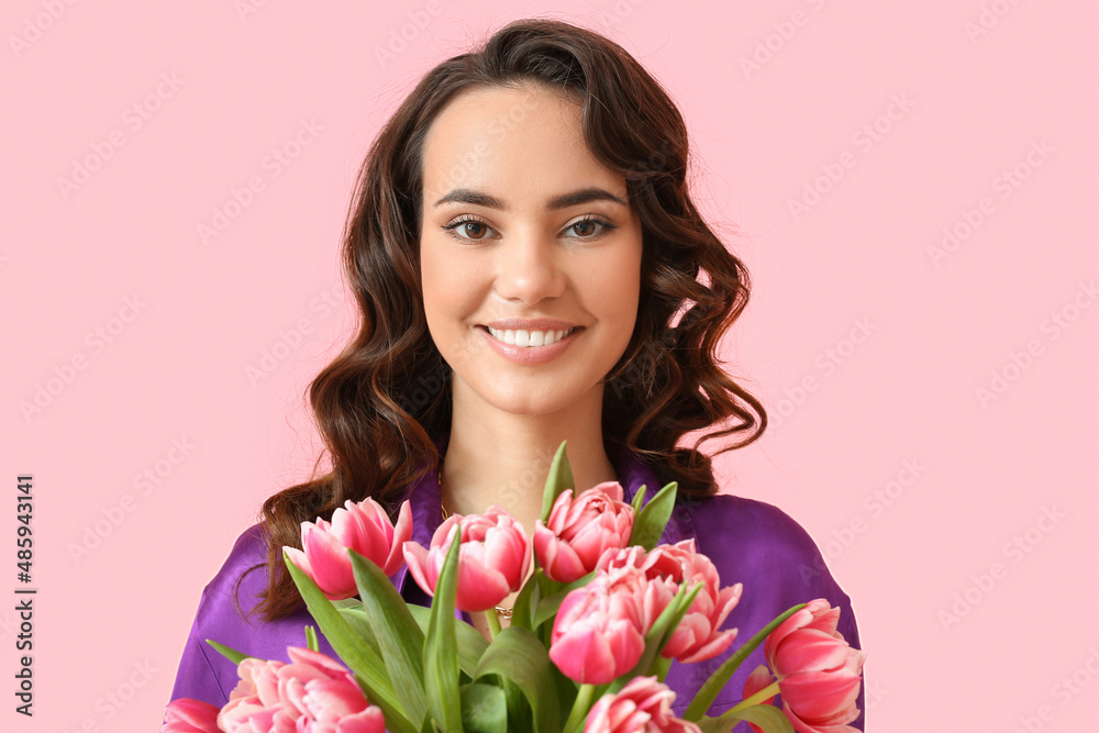 Smiling young woman with bouquet of tulips on pink background. International Women's Day Smiling young woman with bouquet of tulips on pink background. International Women's Day