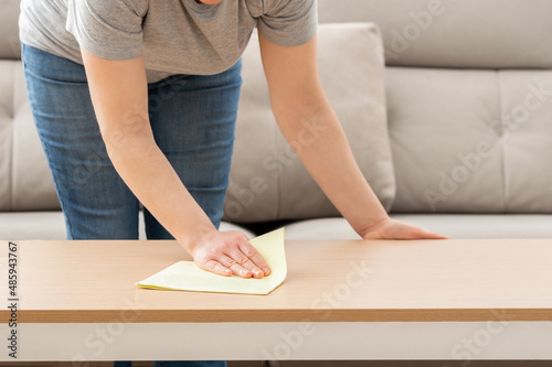 Shot of a young woman cleaning the surface of a table with cleaning equipment at home during the day