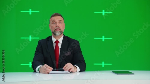 Newsroom TV Studio Live News Program with Green Screen Background: Male Presenter Reporting, Talking. Television Cable Channel Anchor. Network Broadcast Mock-up Playback with Tracking Markers photo