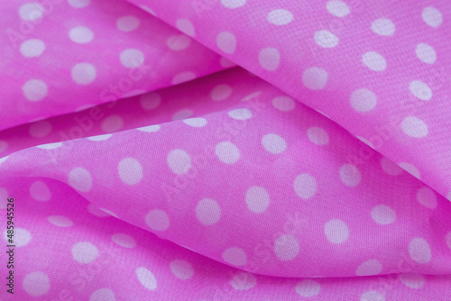 Close-up photo of pink fabric with white circles. Great as a backdrop