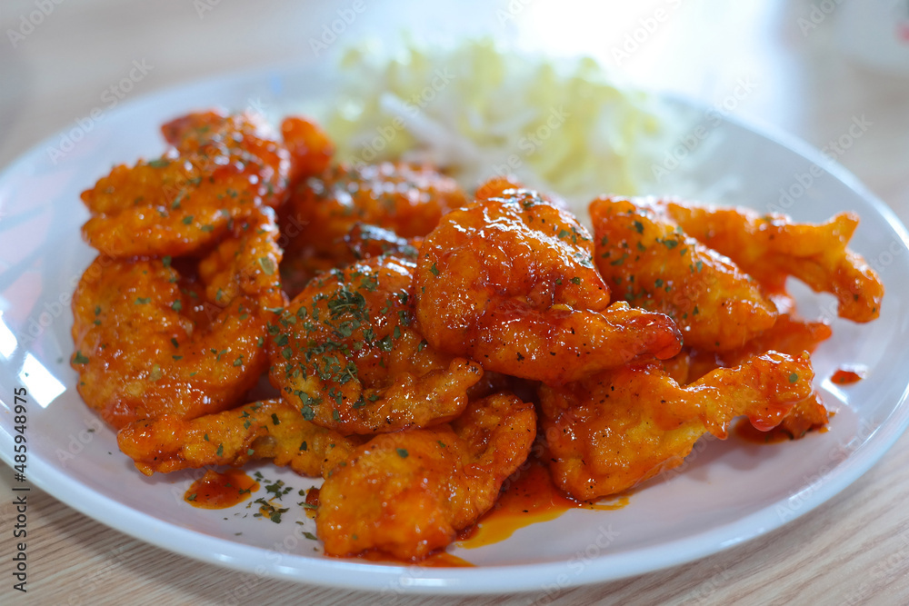 Shrimp dishes fried in chili sauce are served on a white plate. Shrimp dishes fried in chili sauce are served on a white plate.