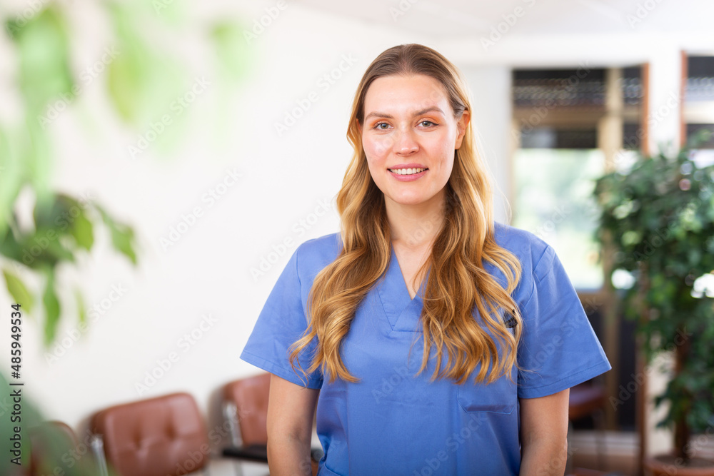 Portrait of friendly female doctor wearing uniform standing in modern clinic
