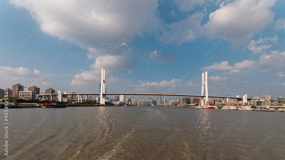 Landscape of Shanghai Nanpu bridge and city skyline viewed from sailing ship in sunny day.