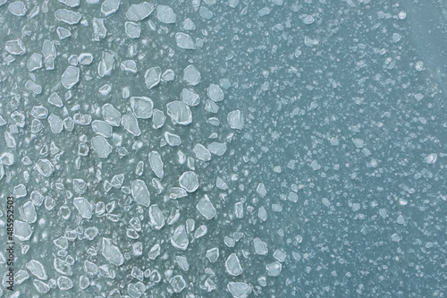In winter, the sea froze, turning into an ice field of frozen ice floes. Background of frozen ice cubes. Winter day frozen sea view from above on sea water ice texture.