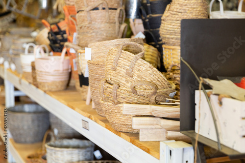 Wicker baskets and other handmade items on store shelves closeup