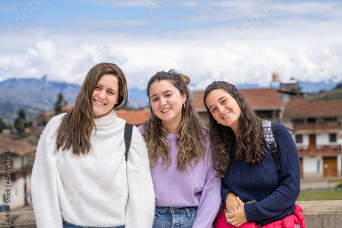 Portrait of three student girls smiling to the camera outdoors