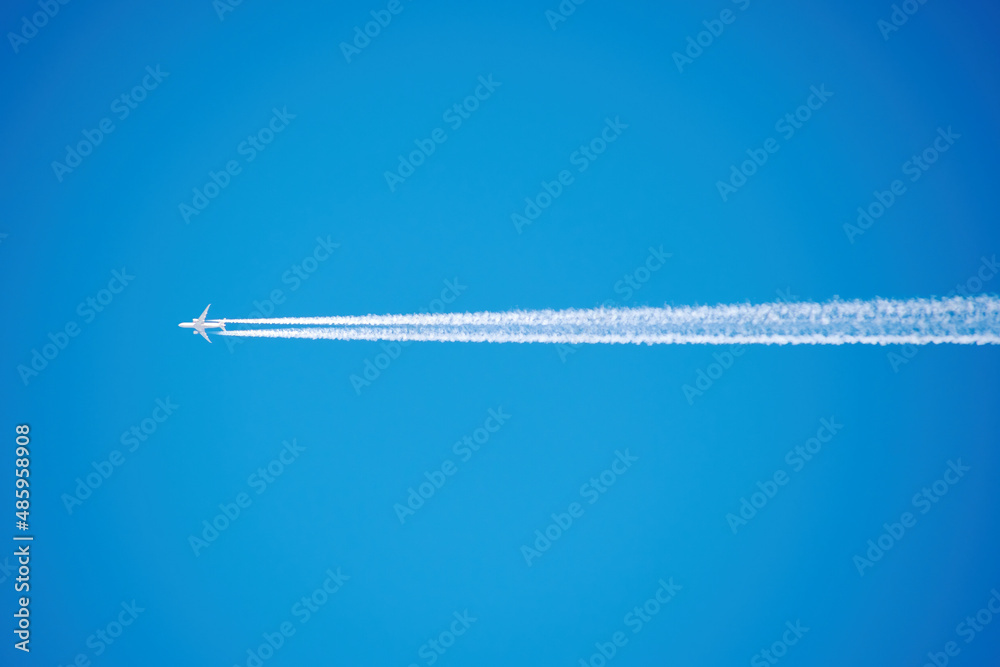 A small passenger plane high in the sky, along with a white trail. Transportation and holidays backgrounds A small passenger plane high in the sky, along with a white trail. Transportation and holidays backgrounds