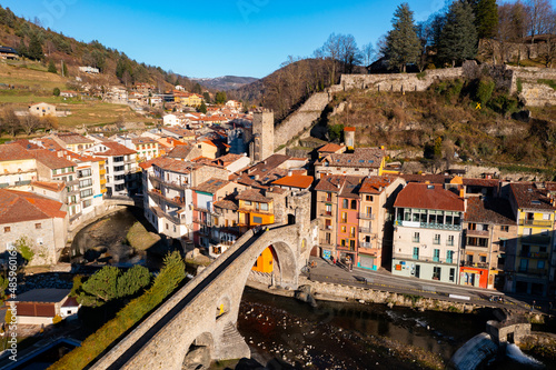 Picturesque autumn view of mountainous Spanish town of Camprodon in Pyrenees with ancient stone bridge across Ter river on sunny day, Girona, Catalonia