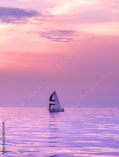  Small Sail boat in a pink and purple sunset on lake Michigan in Michigan USA