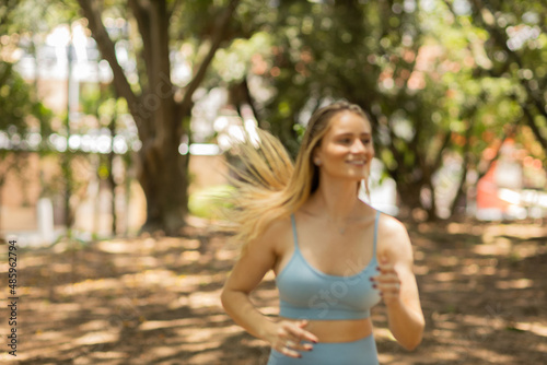 Young woman running and jogging at a park outdoors. Athlete female person during workout. High quality photo