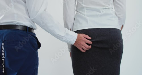 Harassment scene. Male hand groping female buttock. Static, white background photo