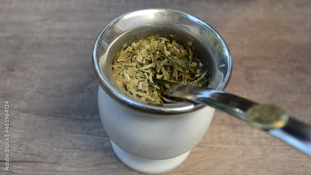 Cebando un mate con hierbas. Mate, infusión que se prepara con las hojas de la yerba mate.