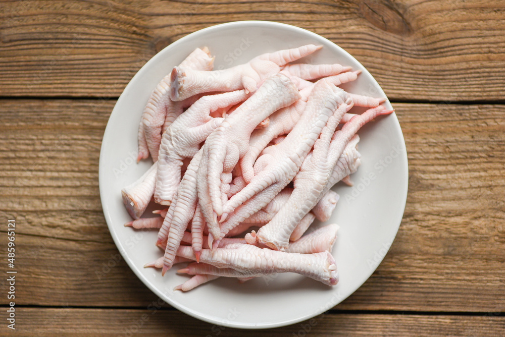 chicken feet on white plate, Fresh raw chicken feet for cooked food on the wooden table kitchen background, top view chicken feet on white plate, Fresh raw chicken feet for cooked food on the wooden table kitchen background, top view