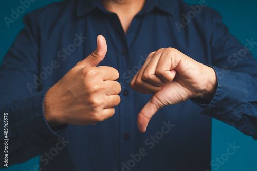 Close-up of two hands showing thumbs up and thumbs down sign. Yes or No. Like or unlike, dislike.