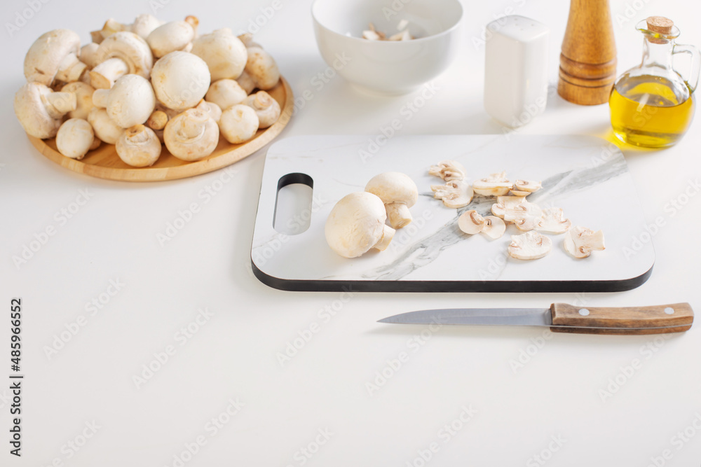 raw champignons on white kitchen table raw champignons on white kitchen table