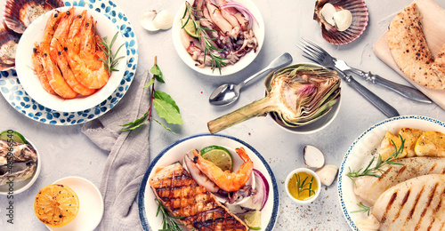 Grilled fish and seafood assortment on light background.