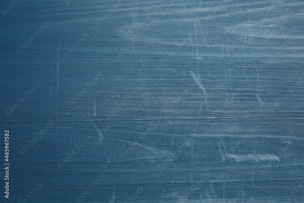 Old blue wooden surface with scratches as background, closeup