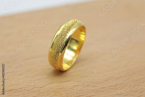 yellow gold ring placed on a wooden floor