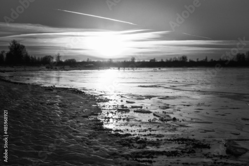 Black and white photo in sunlight. Sunset on the sea coast in pi