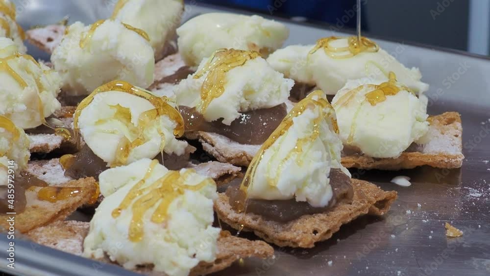 Close-up of fried toasts, with jam and ice cream, on which the cook sprinkles honey on top | static plane Close-up of fried toasts, with jam and ice cream, on which the cook sprinkles honey on top | static plane