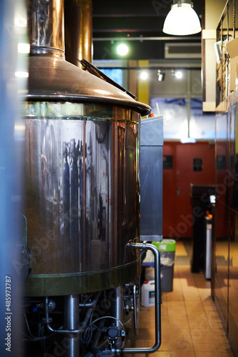 Equipment for the production of handicraft beer. Wort cooking and filtration copper tank. Front view.