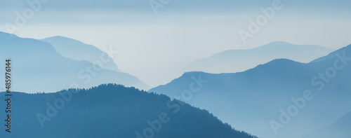 Amazing aerial landscape at the Alps in winter season. Foggy and humidity in the air. Italian alps. Silhouette of the mountains and summits