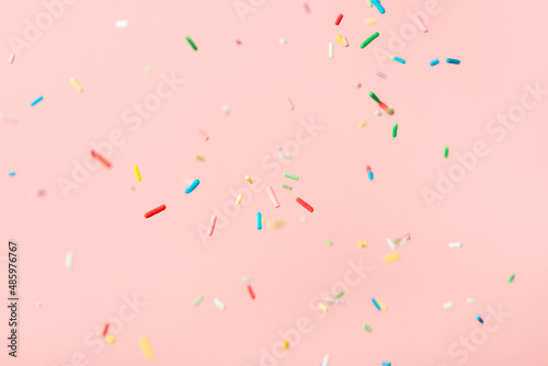 flying colorful sprinkles over pink background