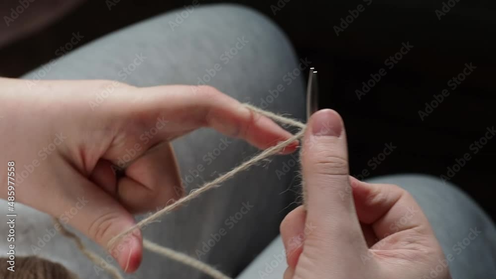 The process of knitting with needles. The hands of a young girl knitting with needles. Handmade concept, hobby, relaxation. The process of knitting with needles. The hands of a young girl knitting with needles. Handmade concept, hobby, relaxation.