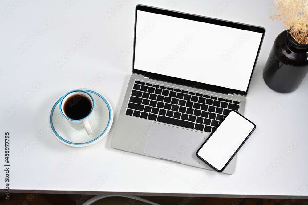 Mockup laptop computer, smart phone, and coffee cup on white table. Mockup laptop computer, smart phone, and coffee cup on white table.