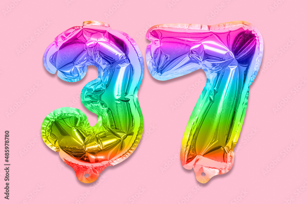 Rainbow foil balloon number, digit thirty seven on a pink background. Birthday greeting card with inscription 37. Top view. Numerical digit. Celebration event, template.