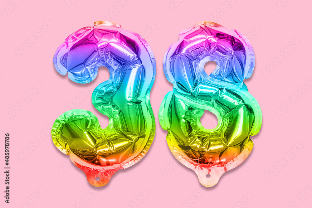 Rainbow foil balloon number, digit thirty eight on a pink background. Birthday greeting card with inscription 38. Top view. Numerical digit. Celebration event, template.