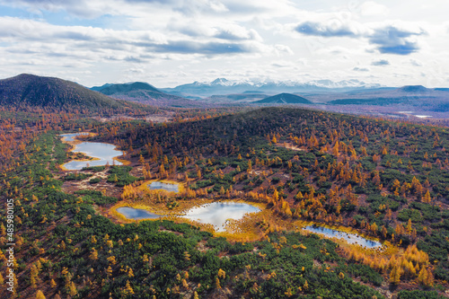 Autumn landscape in the tundra. Mountains, volcanoes, lakes, colored yellow leaves, bright colors