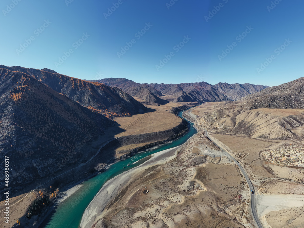 Beautiful autumn mountains valley with blue river and peaks. Aerial drone view