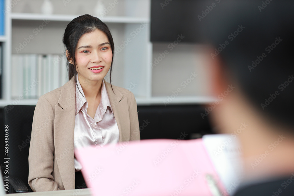 Human resources department managers sitting and interviewing female businesswoman applicant or candidate during job interview in modern office (Focus on female candidate). Business recruitment concept