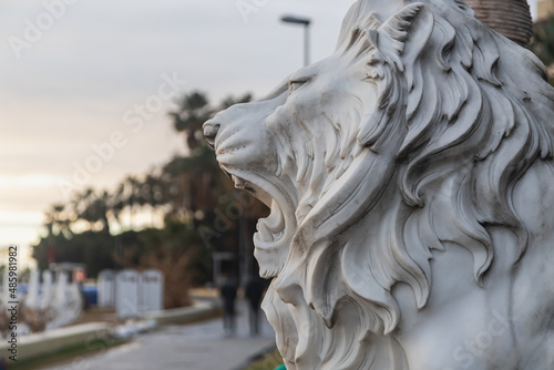 Close-up plaster sculpture of a lion with an open mouth and intimidating teeth