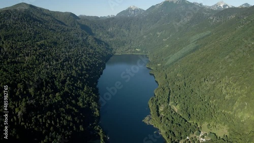 Aerial dolly out of Tinquilco lake between Andean mountains with green rain forest, Huerquehue National Park, Chile photo