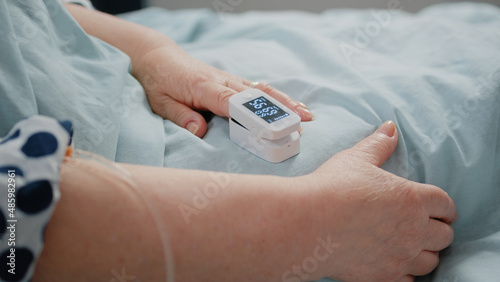 фотографія Close up of oximeter on finger showing low oxygen saturation and pulse pressure
