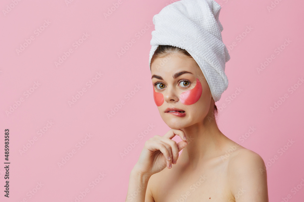 pretty woman pink patches on the face with a towel on the head isolated background pretty woman pink patches on the face with a towel on the head isolated background