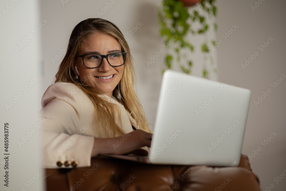 Young woman working at home with laptop and papers on desk and headphones. Home office concept. Young woman working at home with laptop and papers on desk and headphones. Home office concept.