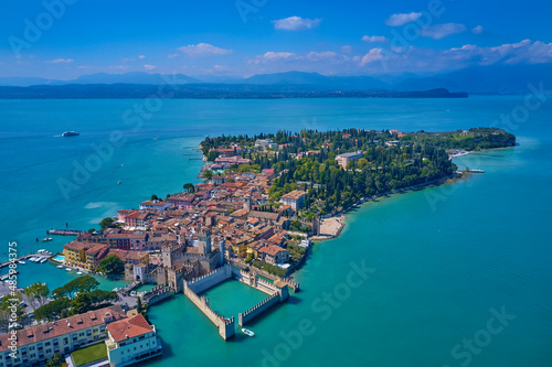 Aerial photography with drone, Rocca Scaligera Castle in Sirmione. Garda, Italy. Aerial view of Sirmione. Sirmione Castle, Lake Garda, Italy. The flag of Italy on the main tower of the castle. 