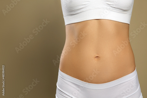 Woman in underwear against beige background, closeup. Space for text