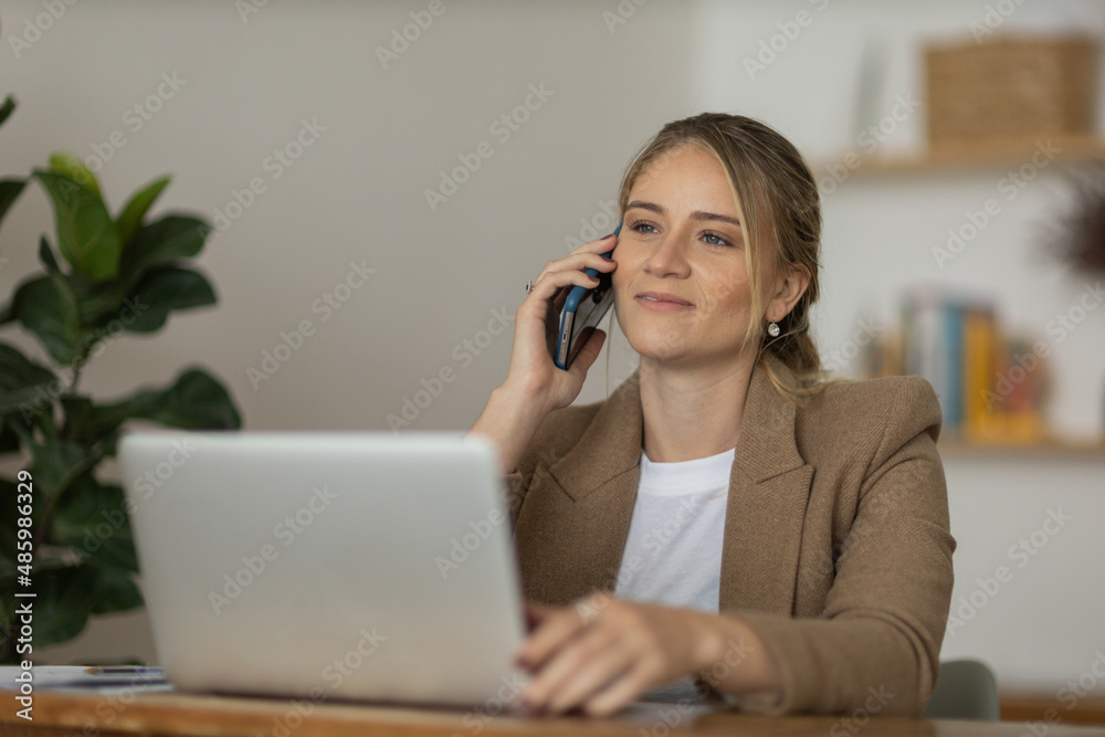 Young woman working at home with laptop and papers on desk. Home office concept.