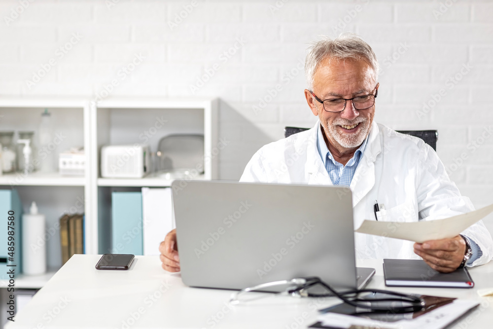 Doctor sitting on table with laptop at his office in ambulance analyze results of patient Doctor sitting on table with laptop at his office in ambulance analyze results of patient