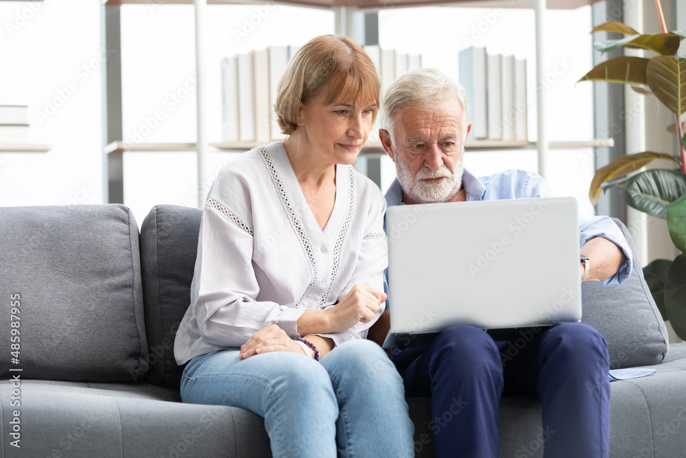 senior couple using laptop computer on sofa senior couple using laptop computer on sofa